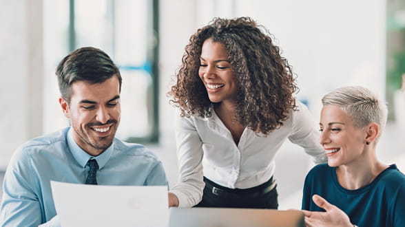 Three office employees looking at a presentation